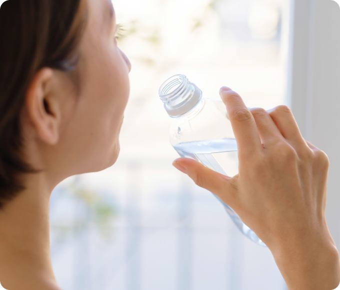 口の渇きを感じて水を飲む女性